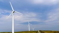 Silhouetted wind turbine at a rural windfarm.