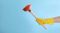 Woman holding plunger on turquoise background, closeup. Space for text