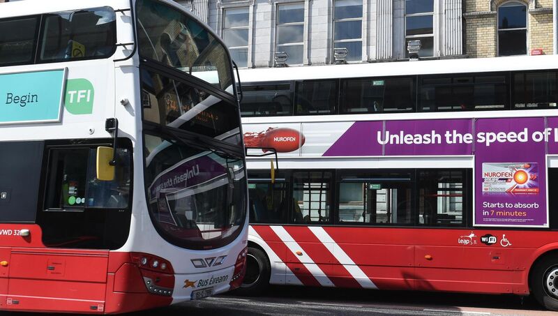 A moving bus passes a Bus Eireann double-decker bus parked on South Mall, Cork. A moving bus passes a Bus Eireann double-decker bus parked on South Mall, Cork.